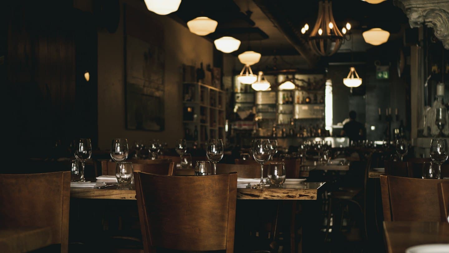Tavoli apparecchiati disposti all'interno di un sofisticato ristorante.