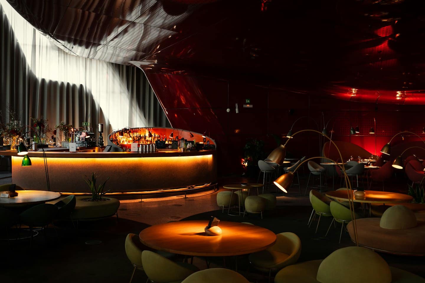 Bar moderno con banconi curvi e zone salotto intime.
