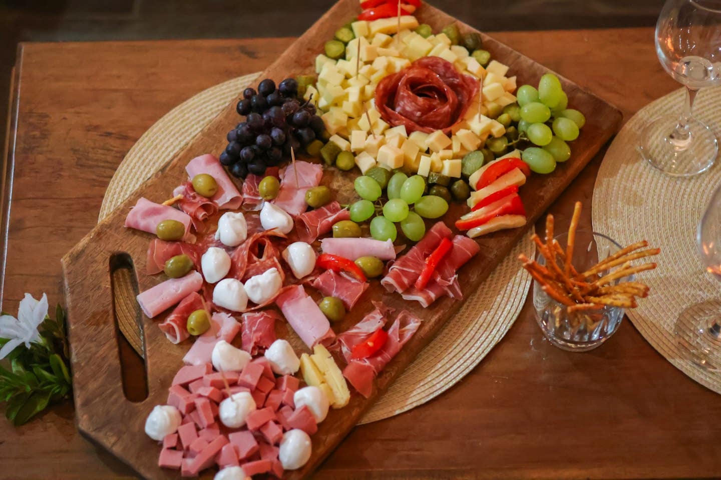 Tagliere rustico in legno con salumi, formaggi e frutta.