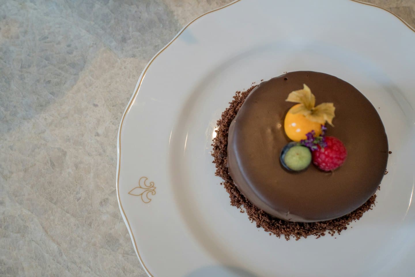 Elegante dolce al cioccolato con frutti di bosco su un piatto bianco a festoni.